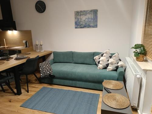 a living room with a green couch and a table at MODERN APARTAMENT Walendów in Walendów