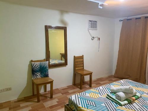 a bedroom with a bed and a mirror and a chair at Kahayag Homestay in Burgos