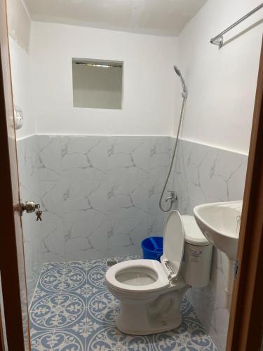 a bathroom with a toilet and a sink at Kahayag Homestay in Burgos