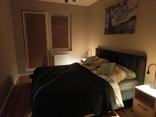 a bedroom with a bed with a black blanket on it at MODERN APARTAMENT Walendów in Walendów