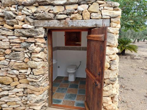 a stone bathroom with a toilet in a stone wall at Landhuisvilla b&b Villa Pardalot in Cálig