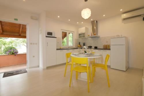 a kitchen with a table and chairs and a refrigerator at Melisa 5 in Poreč