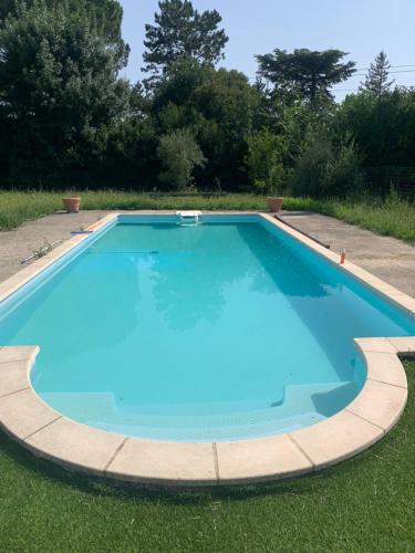 une grande piscine bleue dans l'herbe dans l'établissement Villa Avignon la barthelasse, à Avignon