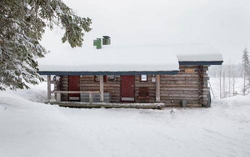 a log cabin with snow on top of it at Kelo 24, kahden makuuhuoneen kelomökki Syötteellä, valaistun ladun vieressä in Pudasjärvi