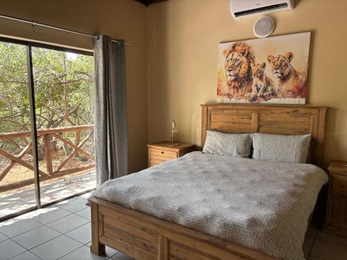 a bedroom with a bed and a large window at Le Lion Dort in Marloth Park