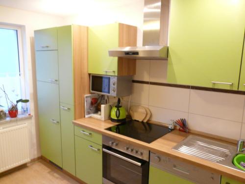 a kitchen with green cabinets and a stove top oven at Ferienwohnung mit Seeblick in Lychen
