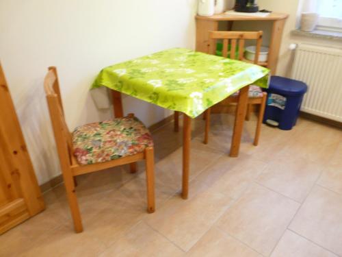 a table and two chairs with a green table cloth on it at Ferienwohnung mit Seeblick in Lychen