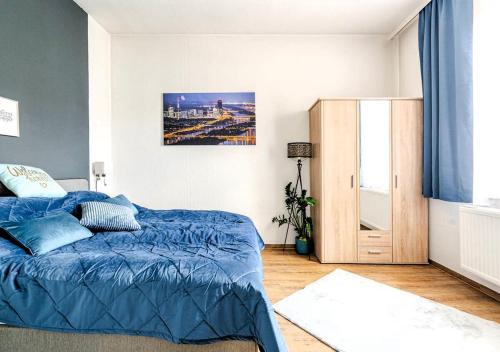 a bedroom with a blue comforter on a bed at Vienna Garden Bungalow in Langenzersdorf