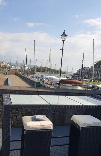 two trash cans sitting next to a marina with boats at lovely apartment porthmadog harbourside views of mountains festiniog railway in Porthmadog