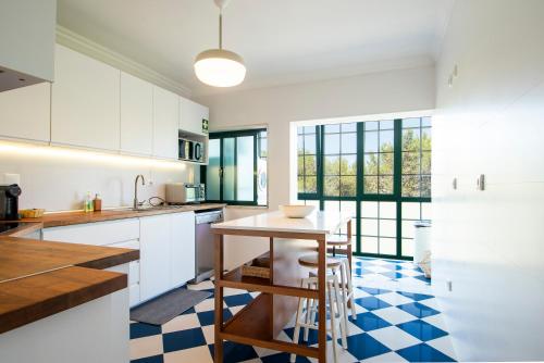 a kitchen with a table and a blue and white checkered floor at Cascais Duplex Apartment in Cascais