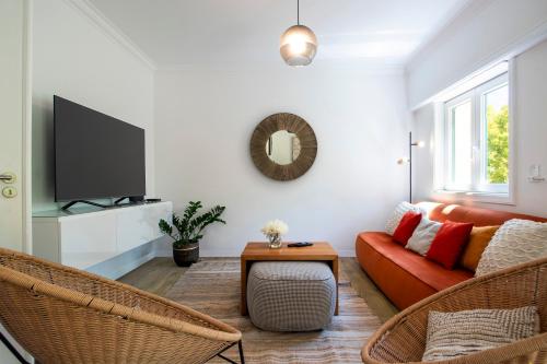 a living room with a couch and a tv at Cascais Duplex Apartment in Cascais