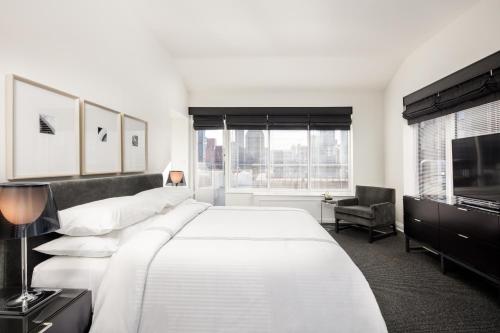 Un dormitorio con una gran cama blanca y una ventana en AKA Sutton Place, en Nueva York