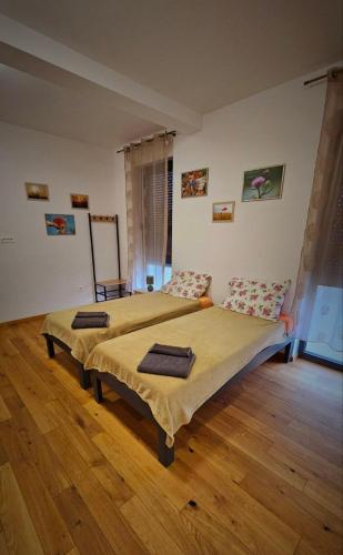 a bedroom with two beds and a wooden floor at festina lente in Osijek