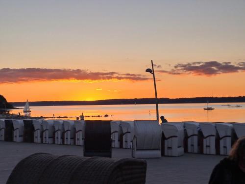 a sunset over a body of water with white barriers at MeerZeit hoch2 in Langballig