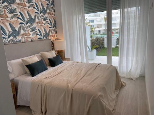 a bedroom with a large bed with a large window at Rinconcito en el Paraíso Costa Ballena in Costa Ballena
