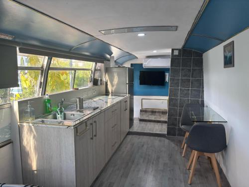 una cucina con tavolo e lavandino di Couples Getaway Bus a Klorakas