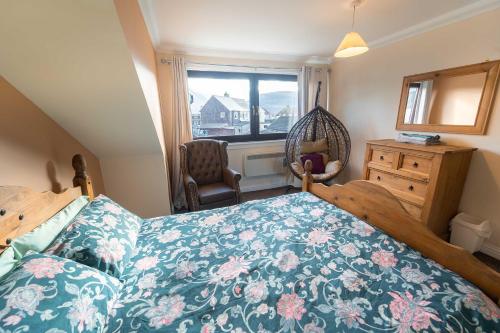 a bedroom with a bed and a window and a chair at Ben View Apartment in Caol