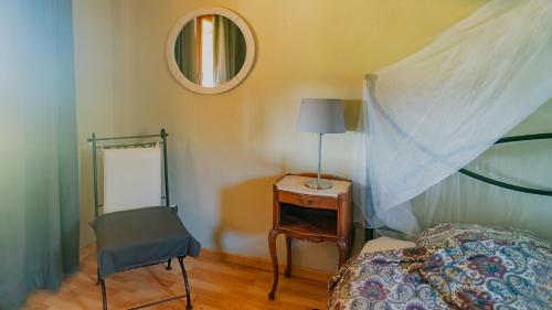 une chambre avec un lit, une chaise et un miroir dans l'établissement Ferienhaus Chalet Natur und Erholung an der Dordogne, à Payrac