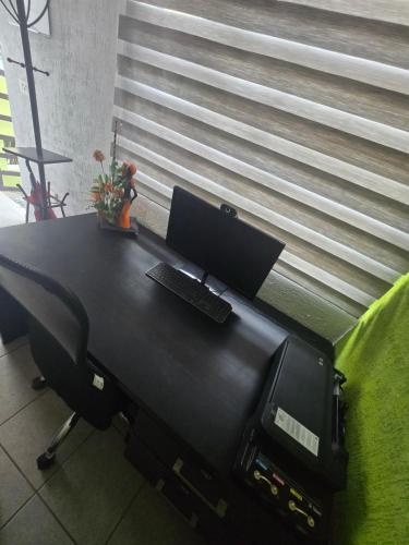 ein Büro mit einem Schreibtisch und einem Computer darauf in der Unterkunft Casa NK in Tierra Colorada