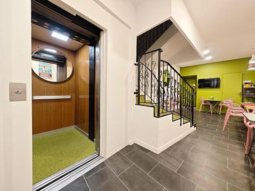 a hallway with a staircase and green walls at Hotel Le Florian in Cannes