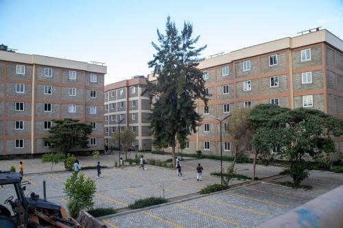 ナクルにあるKings Sapphire Apartments,Nakuruの建物前を歩く人々