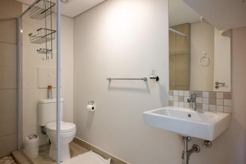 a white bathroom with a sink and a toilet at 226 Millennial Umhlanga in Durban