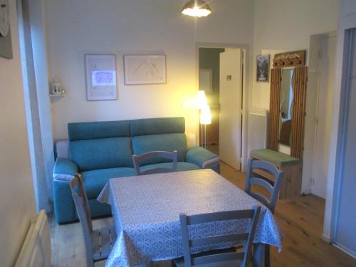 un salon avec un canapé bleu et une table dans l'établissement Appartement Centre de CAUTERETS, à Cauterets