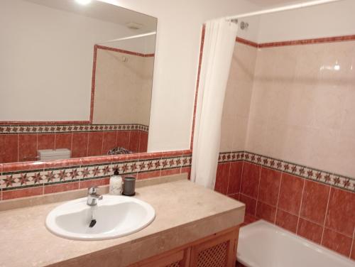 W łazience znajduje się umywalka, wanna i lustro. w obiekcie El Mirador de Estepona w mieście Estepona