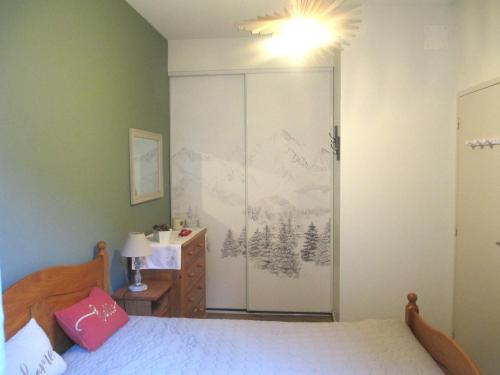 une chambre avec un lit et une porte coulissante en verre dans l'établissement Appartement Centre de CAUTERETS, à Cauterets