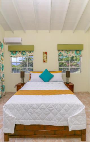 a bedroom with a large bed with two windows at Beautiful 5-bed villa with views and pool - Decaj villa in Cap Estate