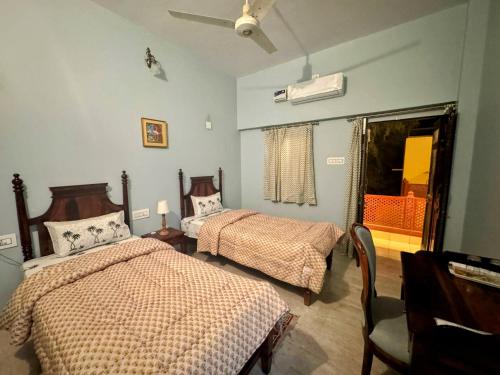 una camera da letto con due letti e un ventilatore a soffitto di Udai Niwas - Bikaner a Bikaner