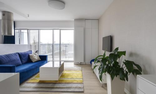 a living room with a blue couch and a tv at Poznań Apartments Towarowa in Poznań