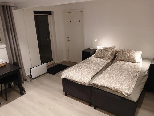 a bedroom with a large bed and a desk and a desk at studio apartment 24 sqm in Trondheim