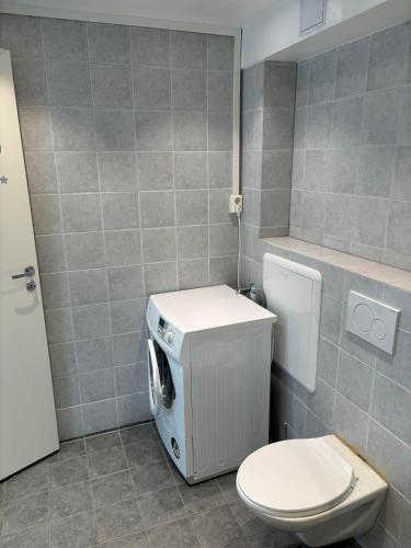a bathroom with a toilet and a washing machine at studio apartment 24 sqm in Trondheim