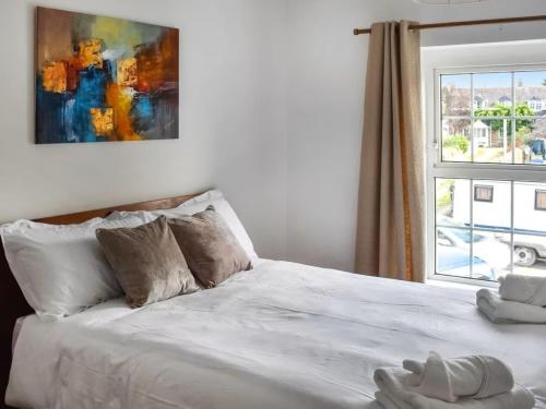 a bedroom with a white bed with a window at The Hideaway - Spacious 3 Bedroom Apartment in Truro