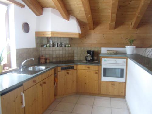 a kitchen with wooden cabinets and a sink at Ferienwohnung Cuntera in Curaglia