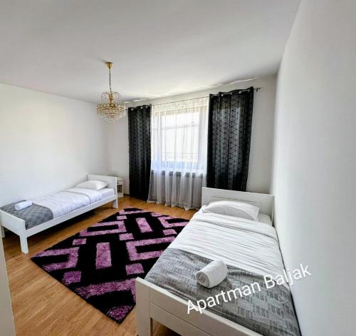 a bedroom with two beds and a purple rug at Apartman Baljak in Livno