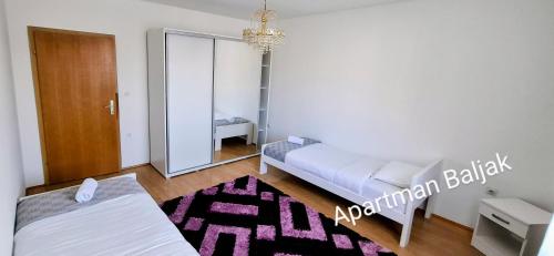 a small bedroom with a bed and a mirror at Apartman Baljak in Livno