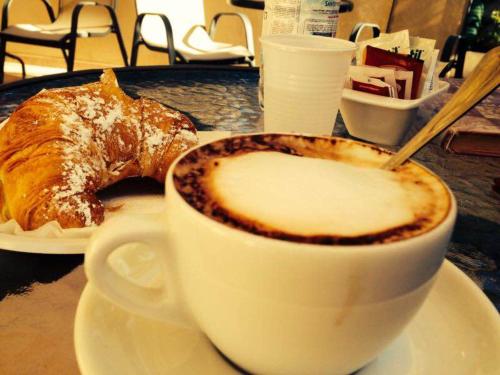 a cup of coffee and a pastry on a table at Residence Casa Del Mar Sicilia in Marina di Modica