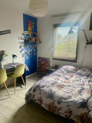 a bedroom with a bed and a desk and a table at Chambre du lac in Mayenne