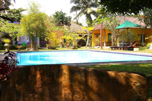 a swimming pool in front of a house at Kurumba Villas in Bentota