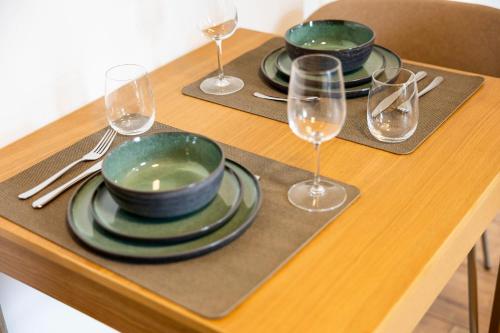 a table with three plates and glasses of wine at NEW - NORA Stays Studio - Messe - Airport in Dresden