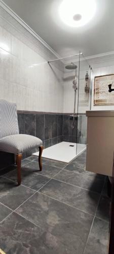 a bathroom with a shower with a bench and a glass shower at Gaztañeta Baserria in Olaeta