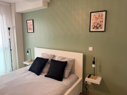 - une chambre avec un lit et deux oreillers noirs dans l'établissement 119 Sous le ciel de Provence - Aix, à Éguilles