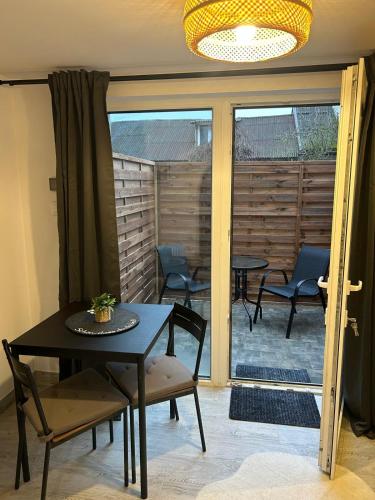 a dining room with a table and chairs and a patio at Apartamenty ARIA in Świnoujście