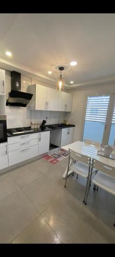 a kitchen with white cabinets and a white table at Aéroport appartement in Tunis