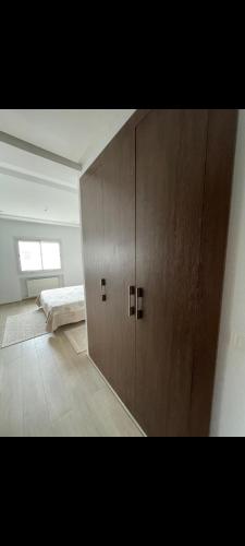 a large wooden cabinet in a room with a bed at Aéroport appartement in Tunis