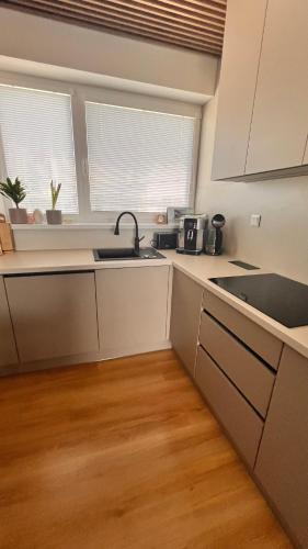 a kitchen with white cabinets and a sink at Rezidencia pod Zámkom Bojnice Apartmán Luna in Bojnice