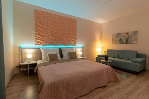 a bedroom with a large bed and a couch at Thermal Residence Apartman in Zalakaros