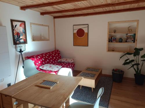 Una sala de estar con una mesa y un sofá rojo. en Appartement cosy en duplex, en Taninges